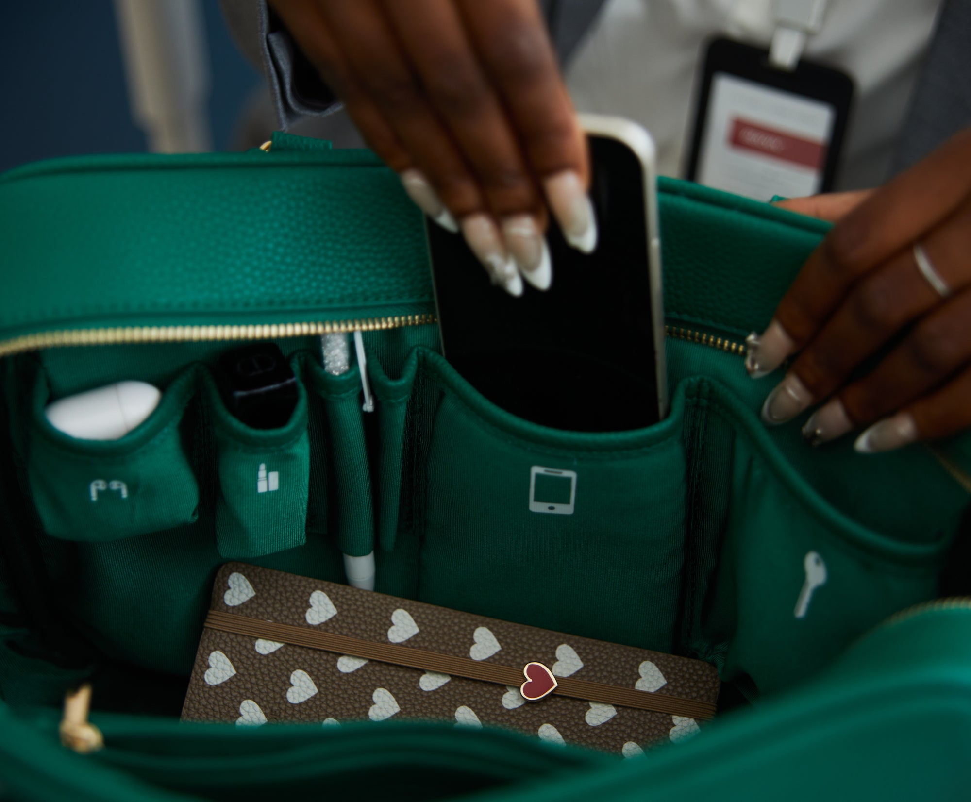 Innenansicht einer grünen Victoria Hyde Handtasche mit Smartphone, Notizbuch und Zubehör – optimale Organisation, nachhaltiges Design, moderne Damenhandtasche für Business und Alltag.