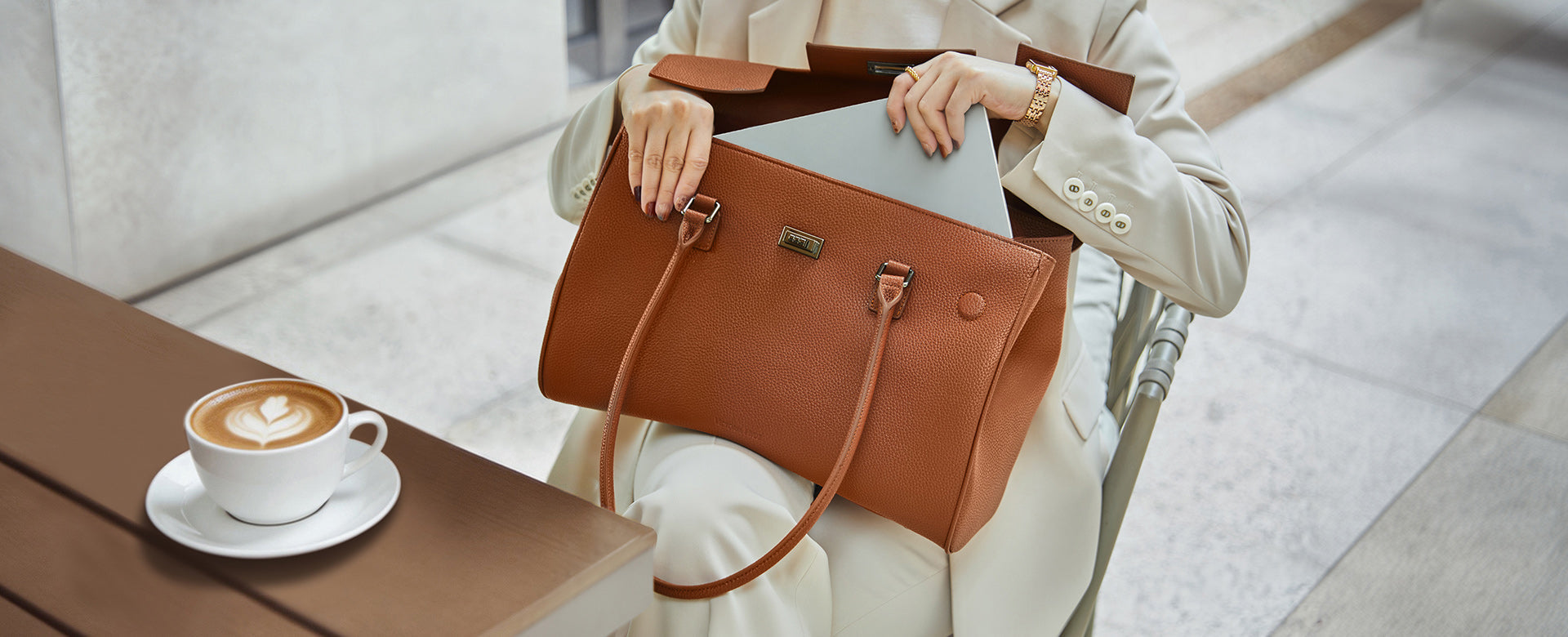 Professionelles mobiles Arbeiten im Café: Die braune Jolene Tasche als stilvoller Business-Begleiter für einen produktiven Arbeitstag.