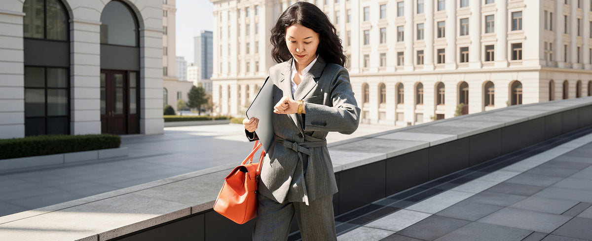Gründerin Tian Yao im dynamischen Business-Look: Mit der orangefarbenen Jolene Tasche unterwegs, perfekt organisiert für den modernen Berufsalltag.