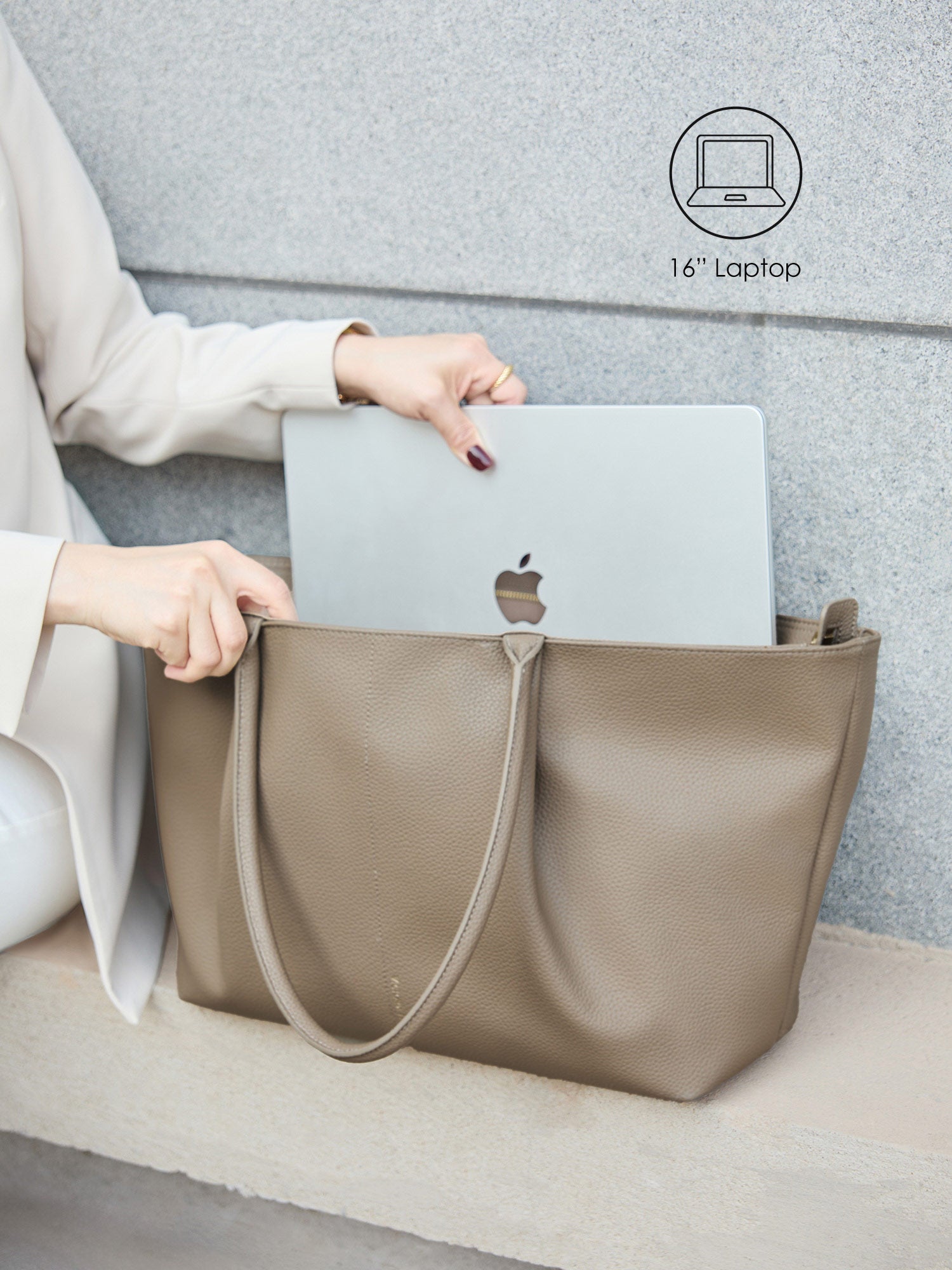 Victoria Hyde Ada beige laptop bag perfectly fitting a 16-inch laptop, demonstrating secure and easy access for professional daily commutes.