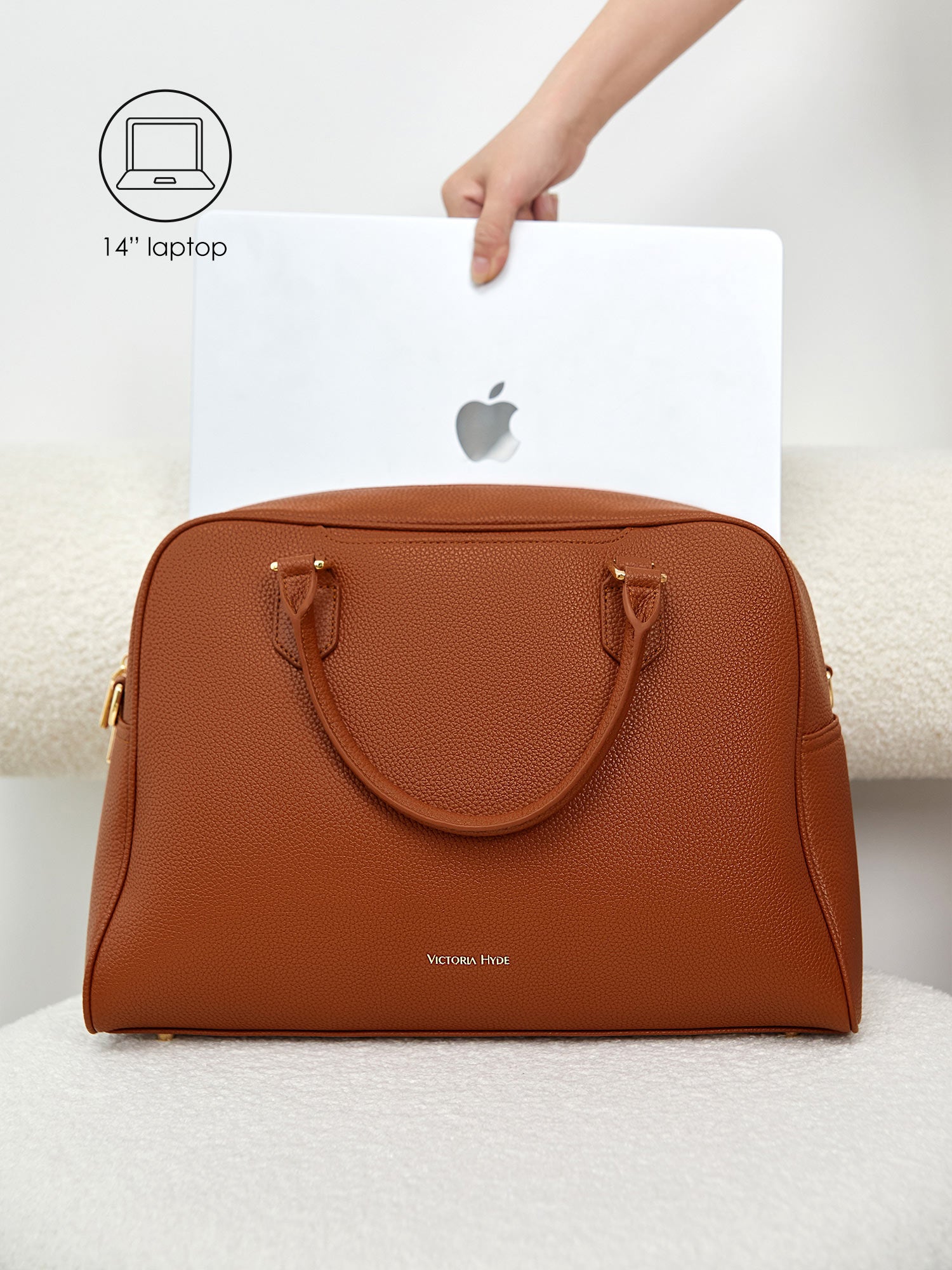 Victoria Hyde Amal brown laptop bag perfectly fitting a 14-inch laptop, demonstrating secure and easy access for professional daily commutes.
