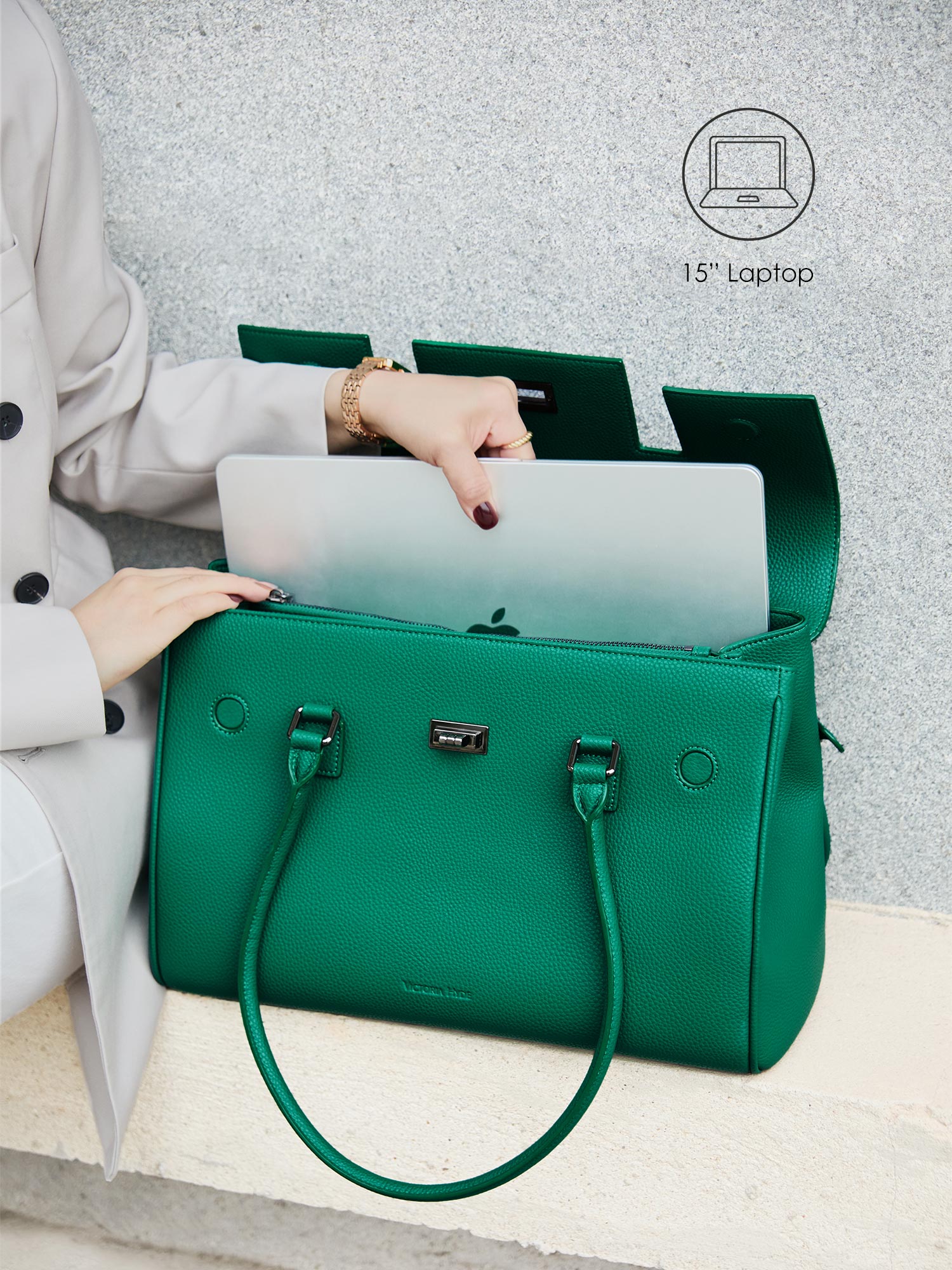 Victoria Hyde Jolene green laptop bag perfectly fitting a 15-inch laptop, demonstrating secure and easy access for professional daily commutes.