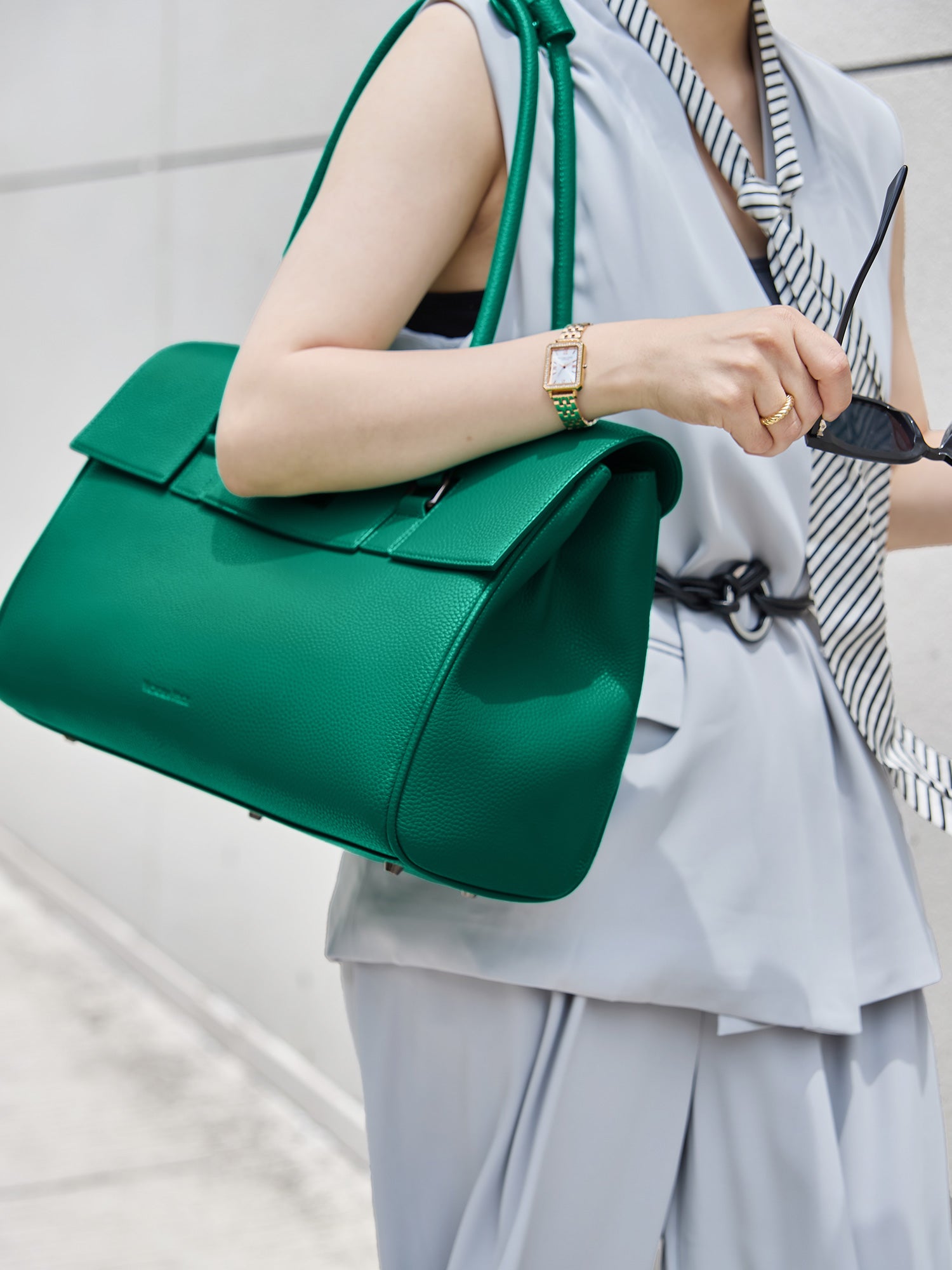 Model carrying the Victoria Hyde Jolene green business laptop bag in brown as a shoulder bag, made of stylish, ergonomic vegan leather.