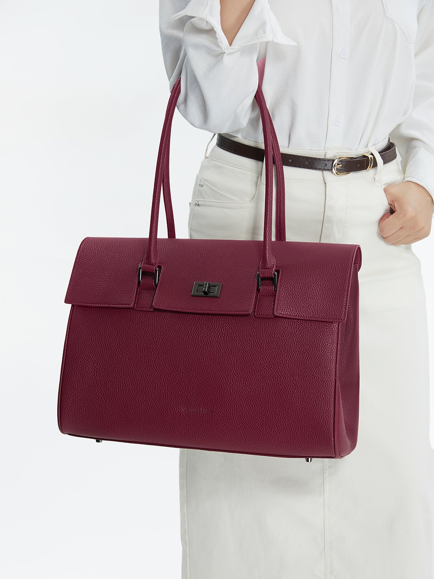 Model carrying the Victoria Hyde Jolene winered business laptop bag in brown as a shoulder bag, made of stylish, ergonomic vegan leather.