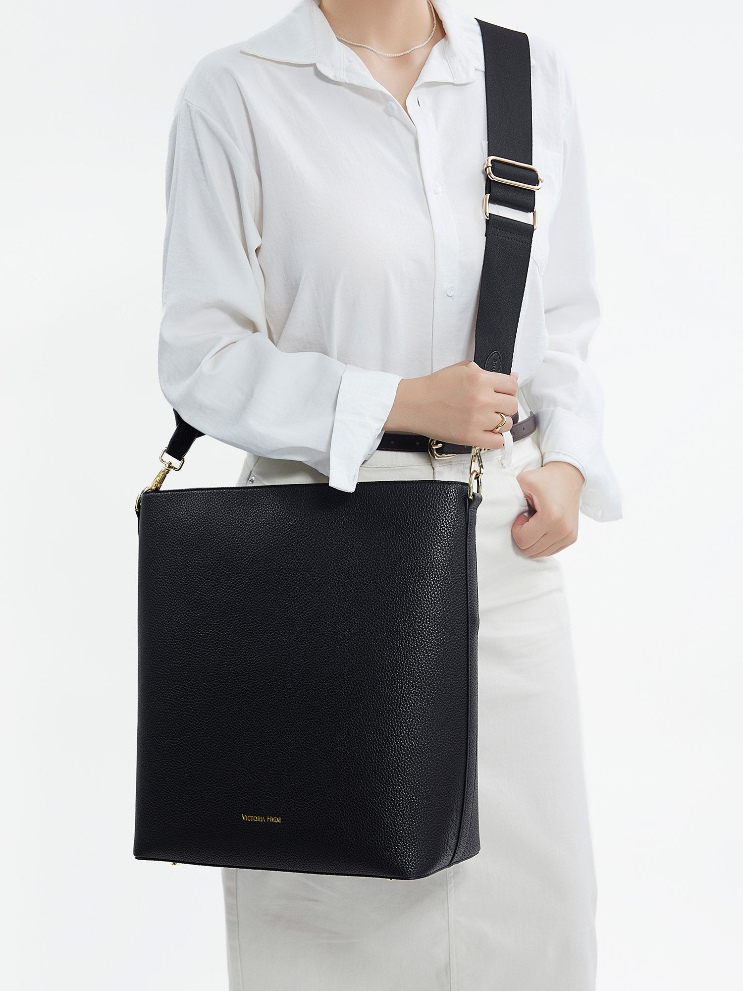 Model carrying the Victoria Hyde Kloey business laptop bag in schwarz as a shoulder bag, made of stylish, ergonomic vegan leather.