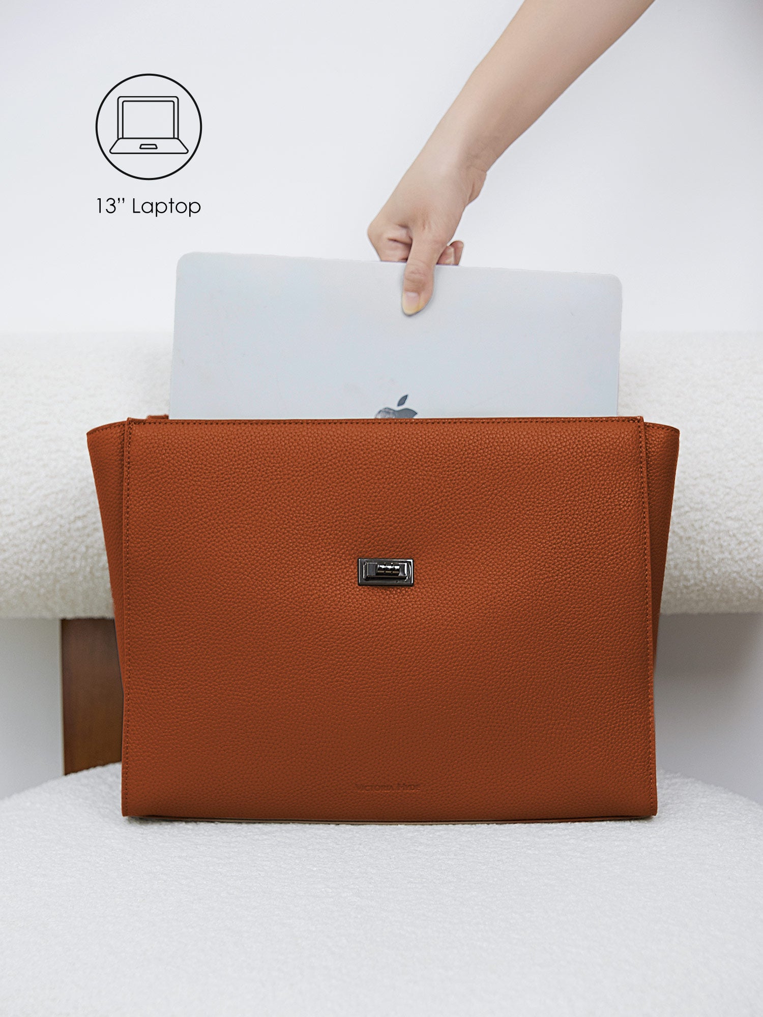 Victoria Hyde Potter braun laptop bag perfectly fitting a 13-inch laptop, demonstrating secure and easy access for professional daily commutes.