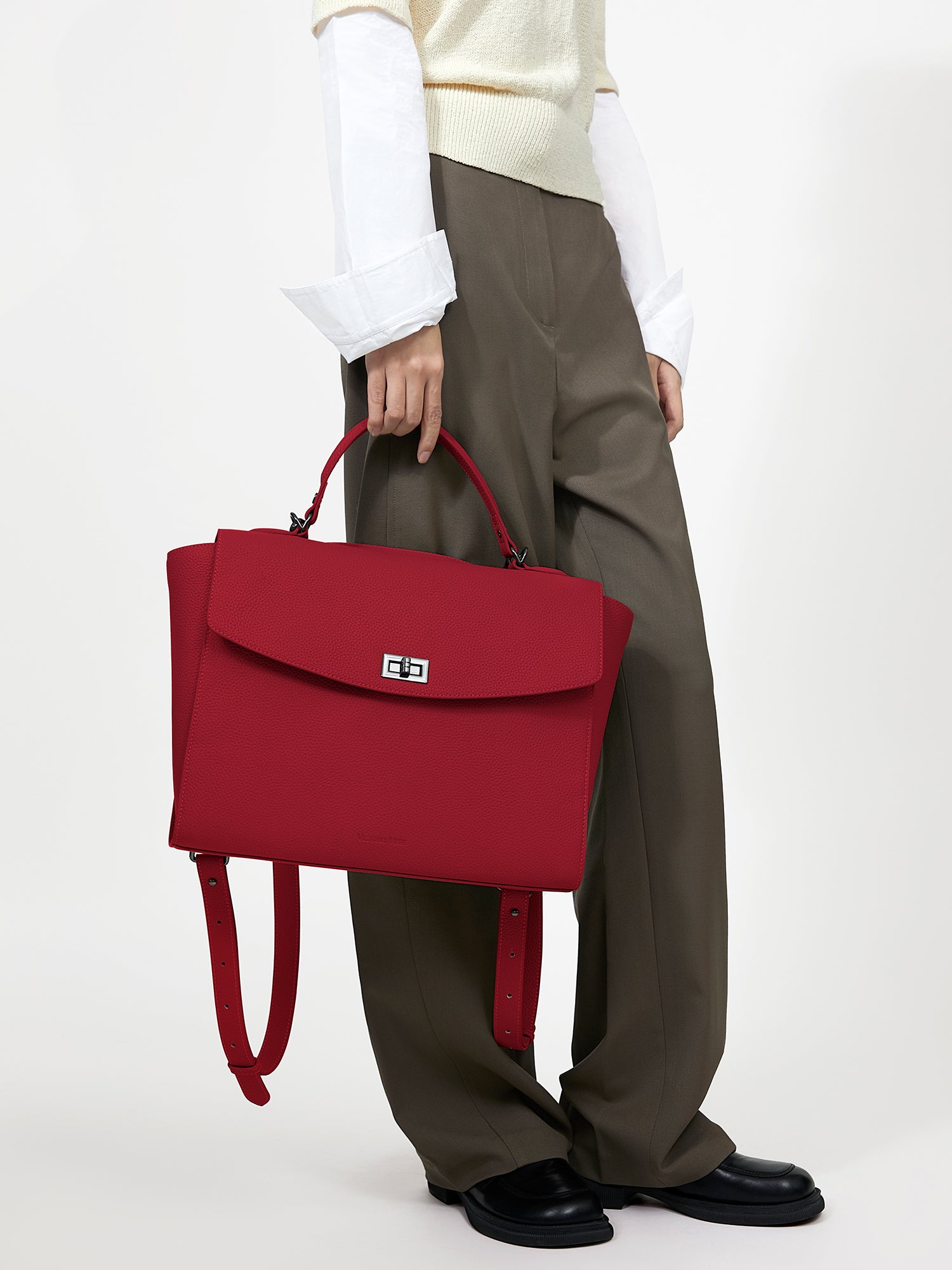 Professional woman carrying the Victoria Hyde Potter Red laptop handbag, elegant vegan leather design with 13-inch laptop compartment for office work.