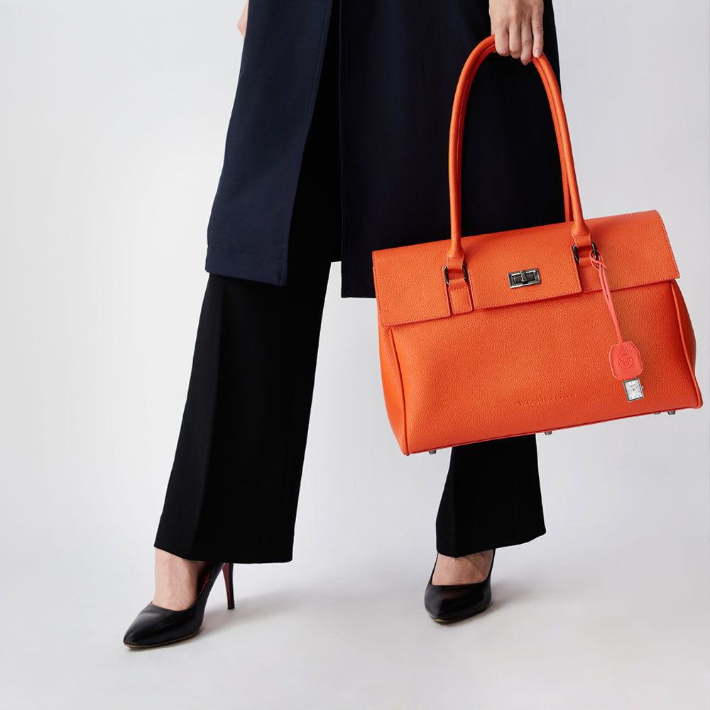 Victoria Hyde orange watch-shaped bag charm with chain. Minimalist design, subtle elegance, functional accessory. Pendant size 40x47 mm. Perfect for timeless style.