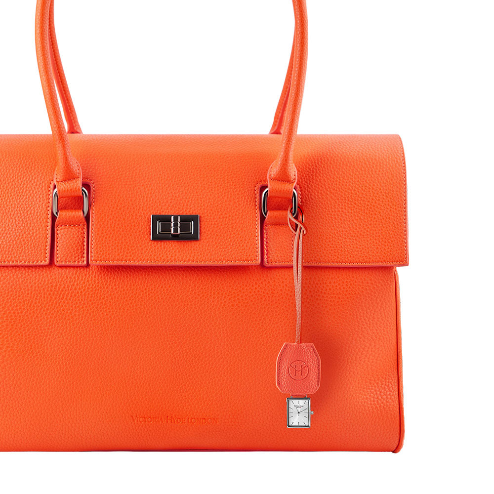 Victoria Hyde orange watch-shaped bag charm with chain. Minimalist design, subtle elegance, functional accessory. Pendant size 40x47 mm. Perfect for timeless style.