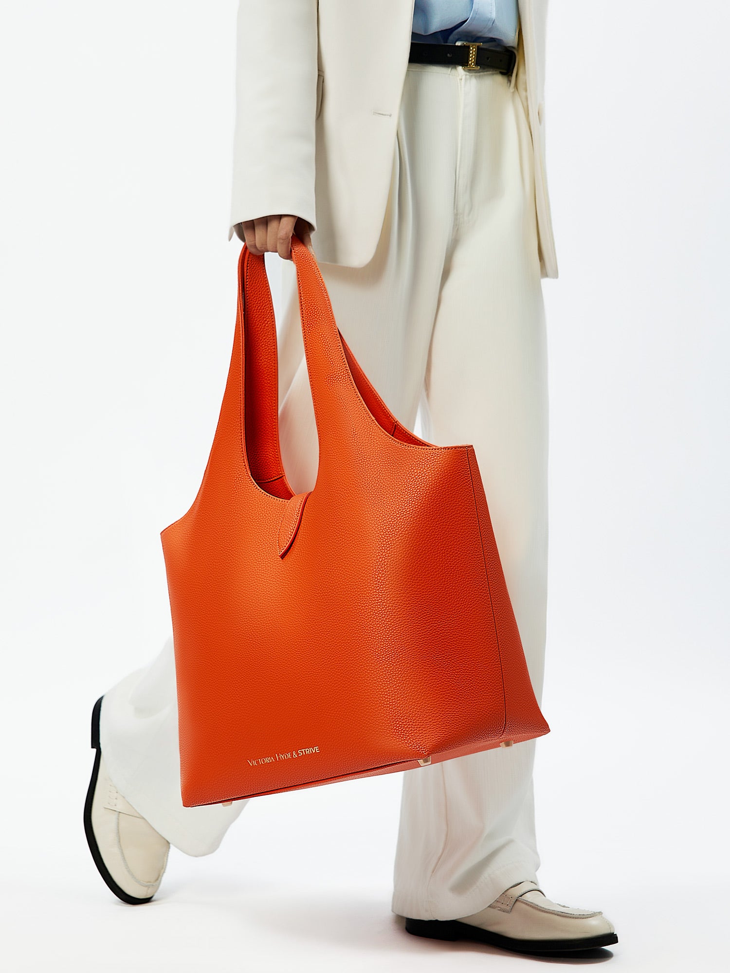 Victoria Hyde Strive Collection orange work bag with thoughtful interior pockets, removable laptop compartment, zippered back with trolley strap, durable microfiber leather, sustainable RPET lining, scratch-resistant &amp; water-repellent. Ideal for professionals.