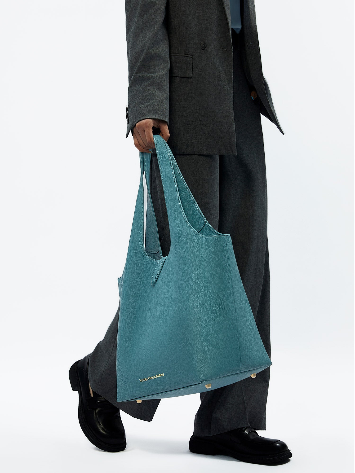 Victoria Hyde Strive Collection turquoise work bag. Microfiber leather, RPET lining. Interior pockets, removable laptop compartment, trolley strap. 0.85kg, 56x32x20 cm.
