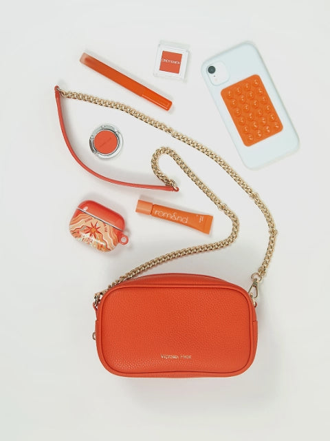 Victoria Hyde Antonia Orange crossbody bag – packing video showing compact interior with key pocket, lipstick pocket, card slot and headphone compartment.