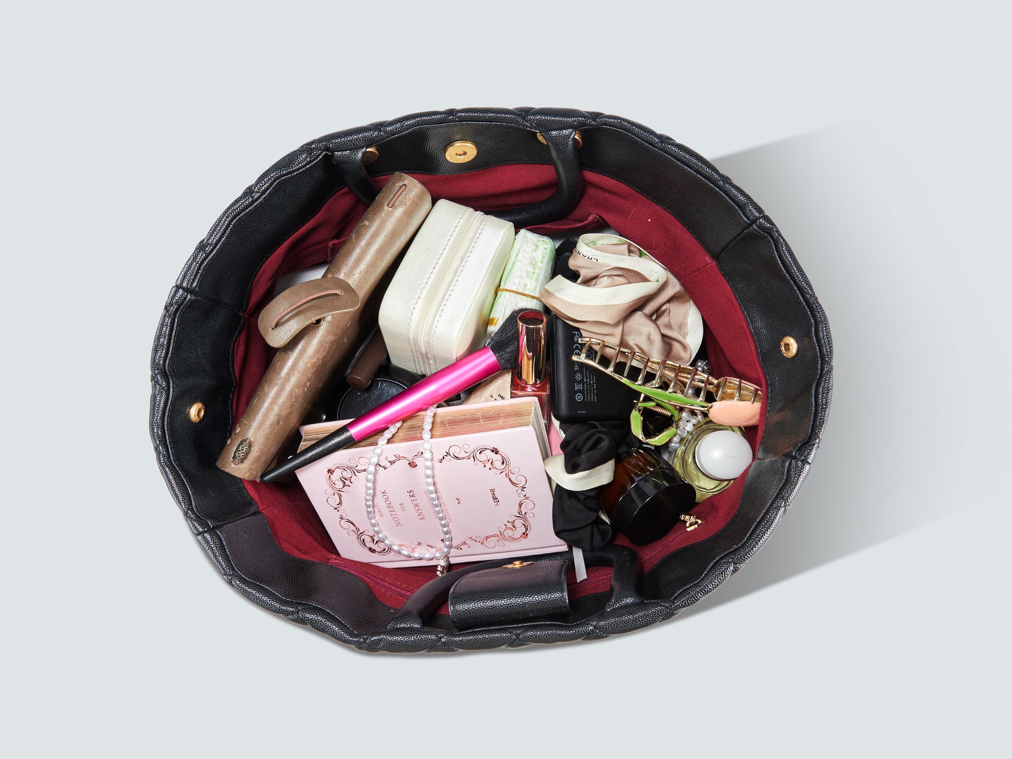 Traditionelle Damenhandtasche mit alltäglichen Gegenständen wie Geldbeutel, Kosmetik und Schlüsseln, im Vergleich zur modernen Victoria Hyde New Work Bag.