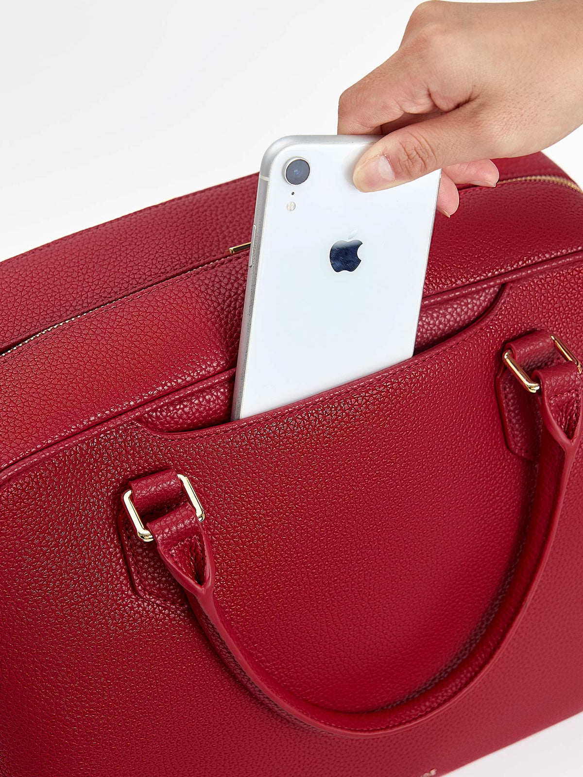 Sliding smartphone into the convenient front quick-access slip pocket of Victoria Hyde Amal garnet red bag