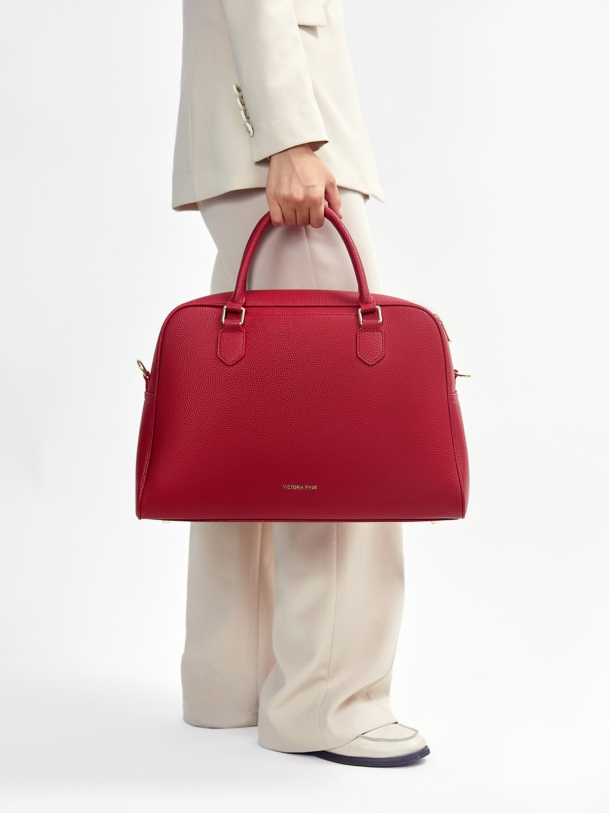 Model carrying Victoria Hyde Amal garnet red convertible business bag for executive styling