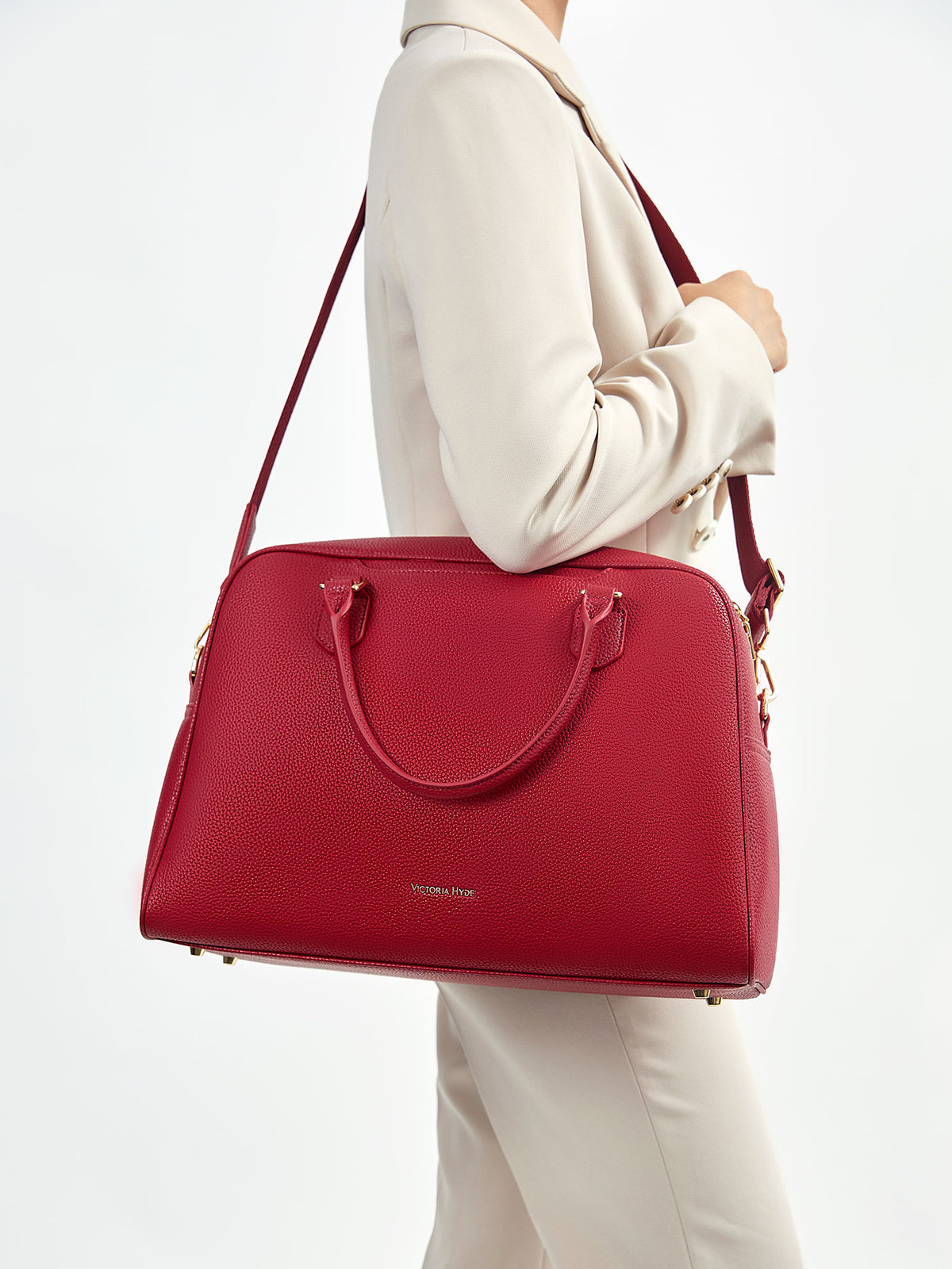Model wearing Victoria Hyde Amal garnet red convertible business bag as a shoulder bag