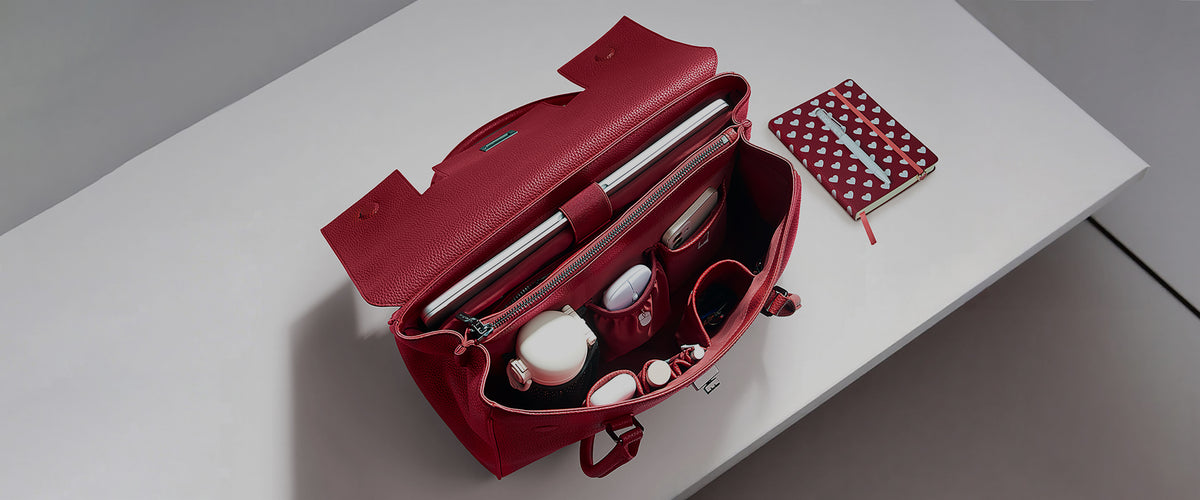 Organized interior top view of Victoria Hyde Jolene large garnet red business bag packed with a 16-inch laptop, water bottle, and daily office accessories