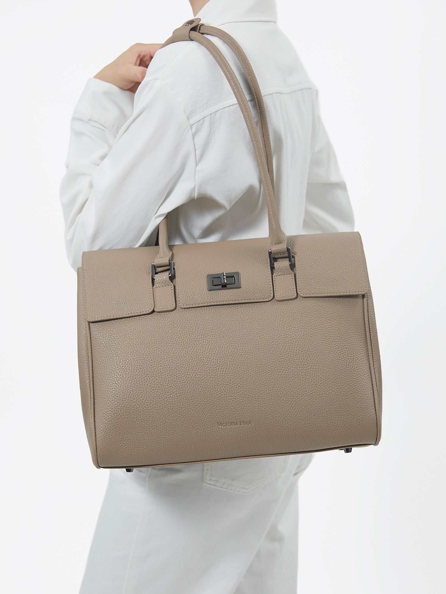 Model carrying Victoria Hyde Jolene Medium beige microfiber leather business shoulder bag for office commute