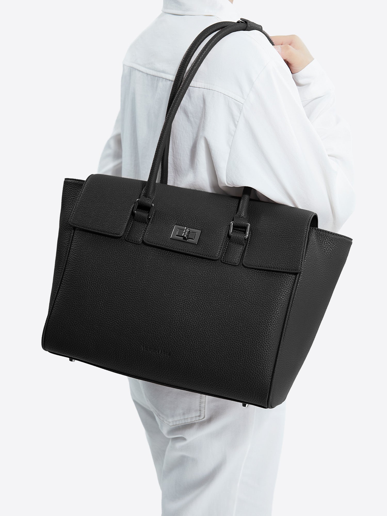 Side view of model carrying the black Victoria Hyde Jolene Medium business bag and shoulder bag for office work