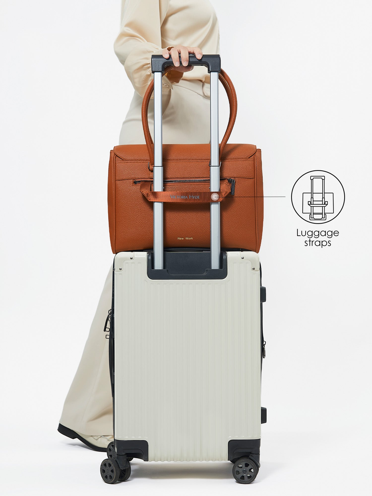 Back view of Victoria Hyde Jolene Medium brown business bag secured on a suitcase handle using the built-in luggage strap for travel