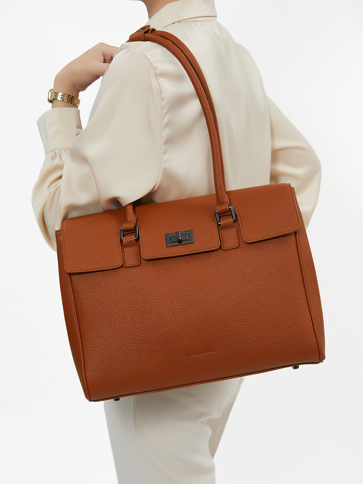 Model carrying Victoria Hyde Jolene Medium brown microfiber leather business shoulder bag for office commute