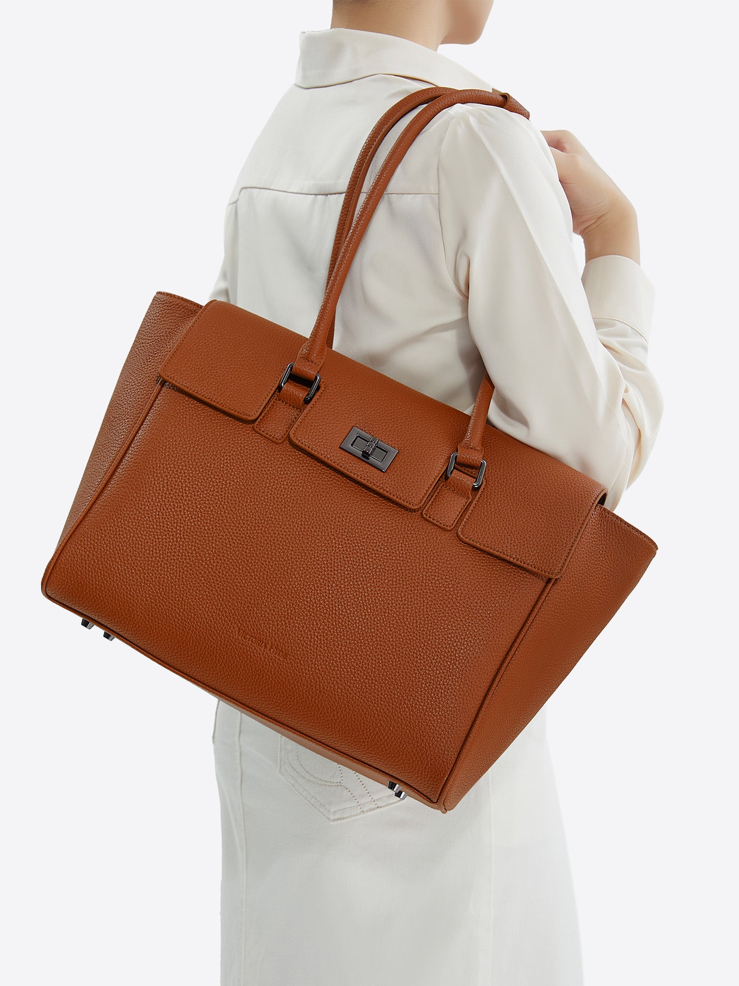 Side view of model carrying the brown Victoria Hyde Jolene Medium business bag and shoulder bag  for office work.