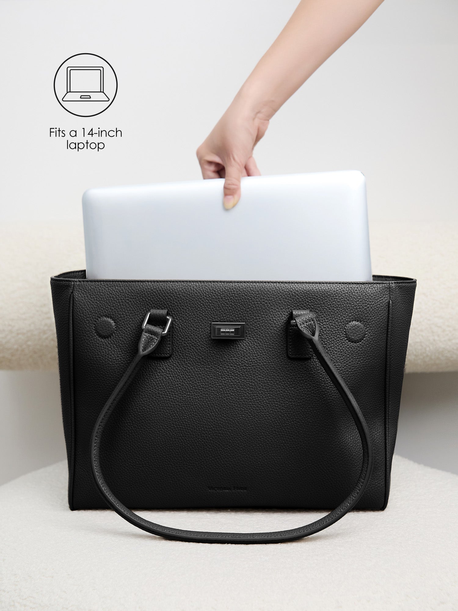 Placing a 14-inch laptop into the padded protective compartment of the Victoria Hyde Jolene Medium business bag