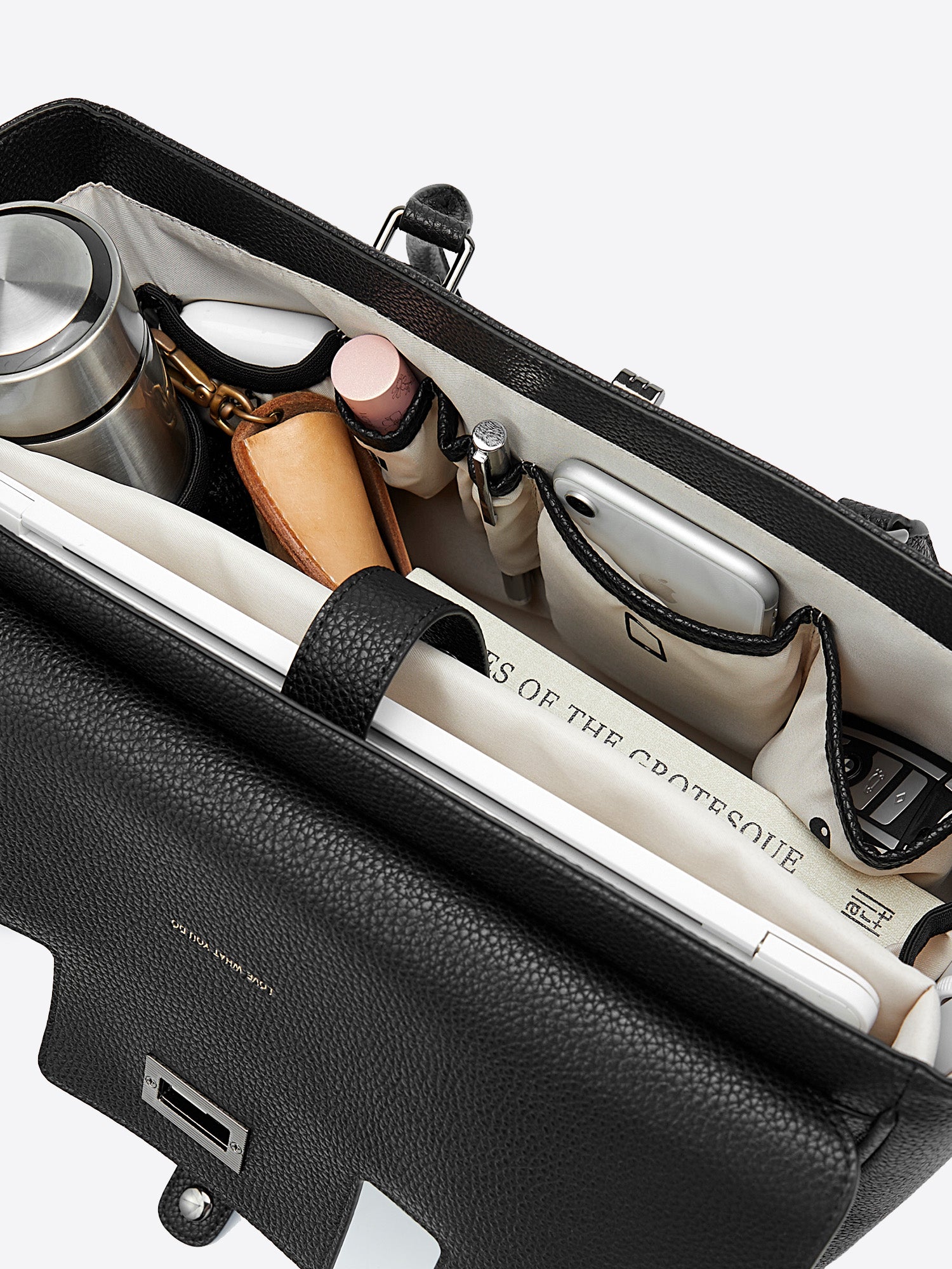 Organized interior top view of Jolene Medium business bag packed with water bottle mesh pocket, cosmetics, and notebook
