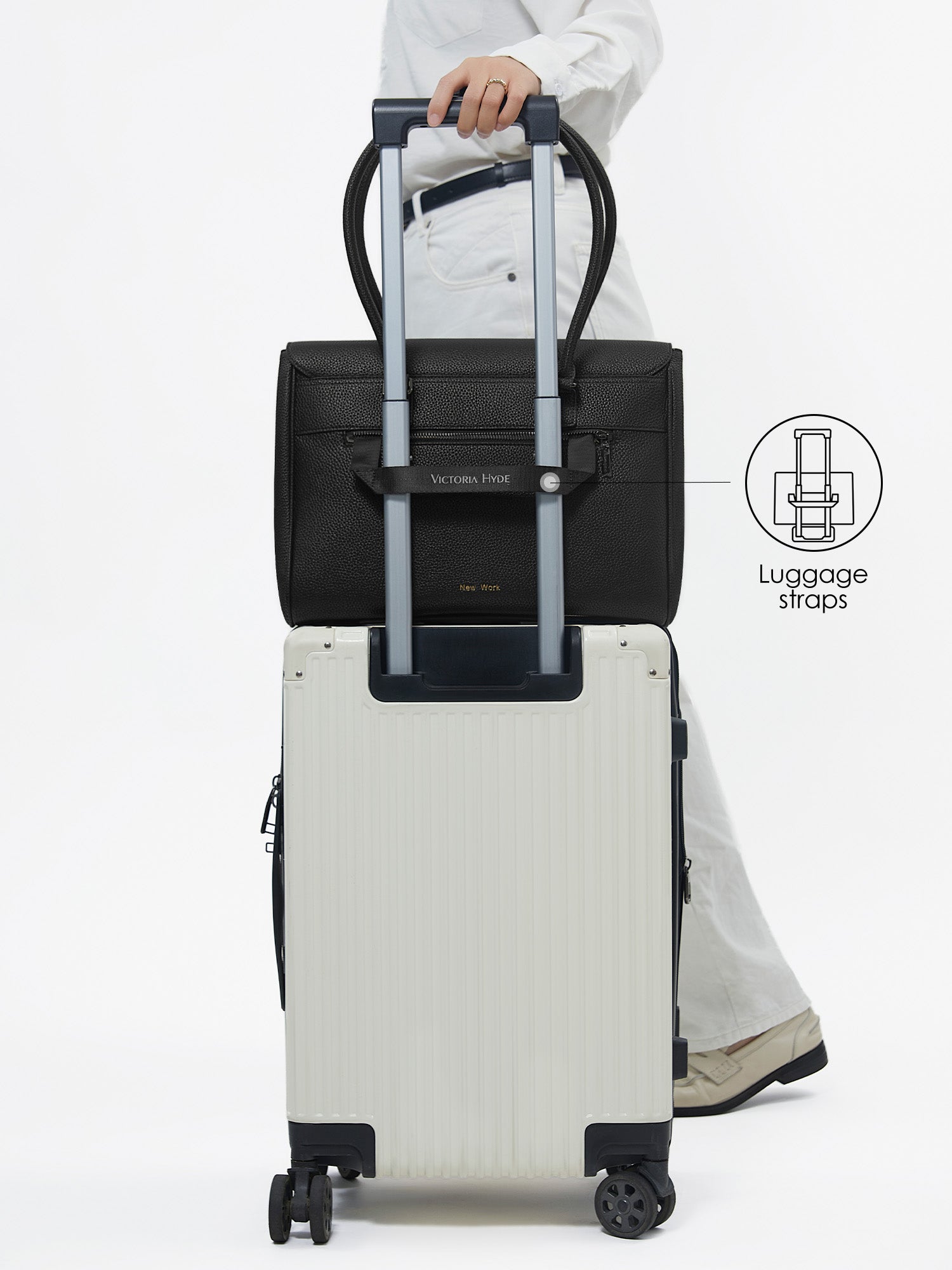 Back view of Victoria Hyde Jolene Medium black business bag secured on a suitcase handle using the built-in luggage strap for travel