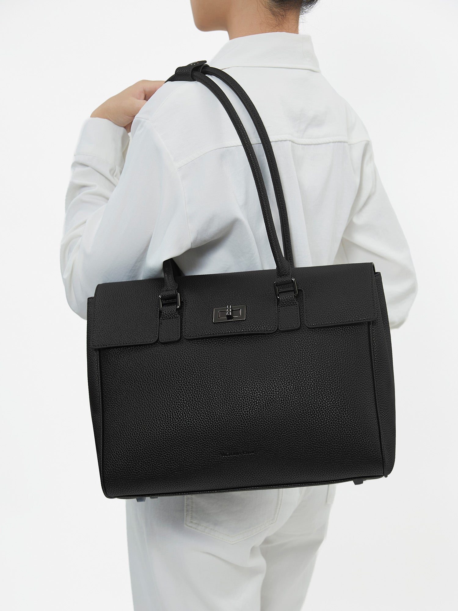 Model carrying Victoria Hyde Jolene Medium black microfiber leather business shoulder bag for office commute