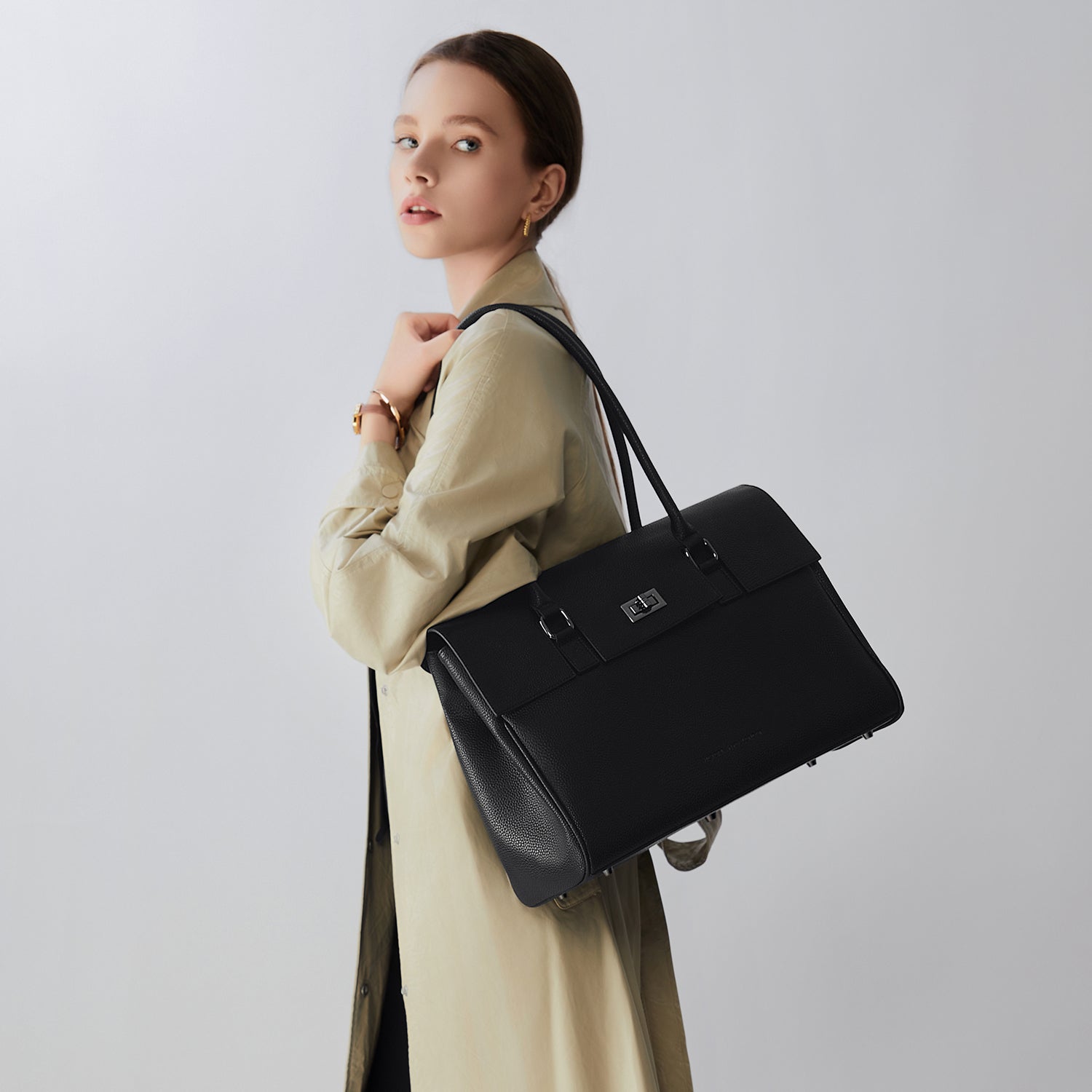 Stilvolle Frau mit der schwarzen Victoria Hyde London Jolene New Work Bag, einer eleganten Business-Handtasche aus Mikrofaser-Leder, ideal für moderne Frauen im Büro-Alltag.