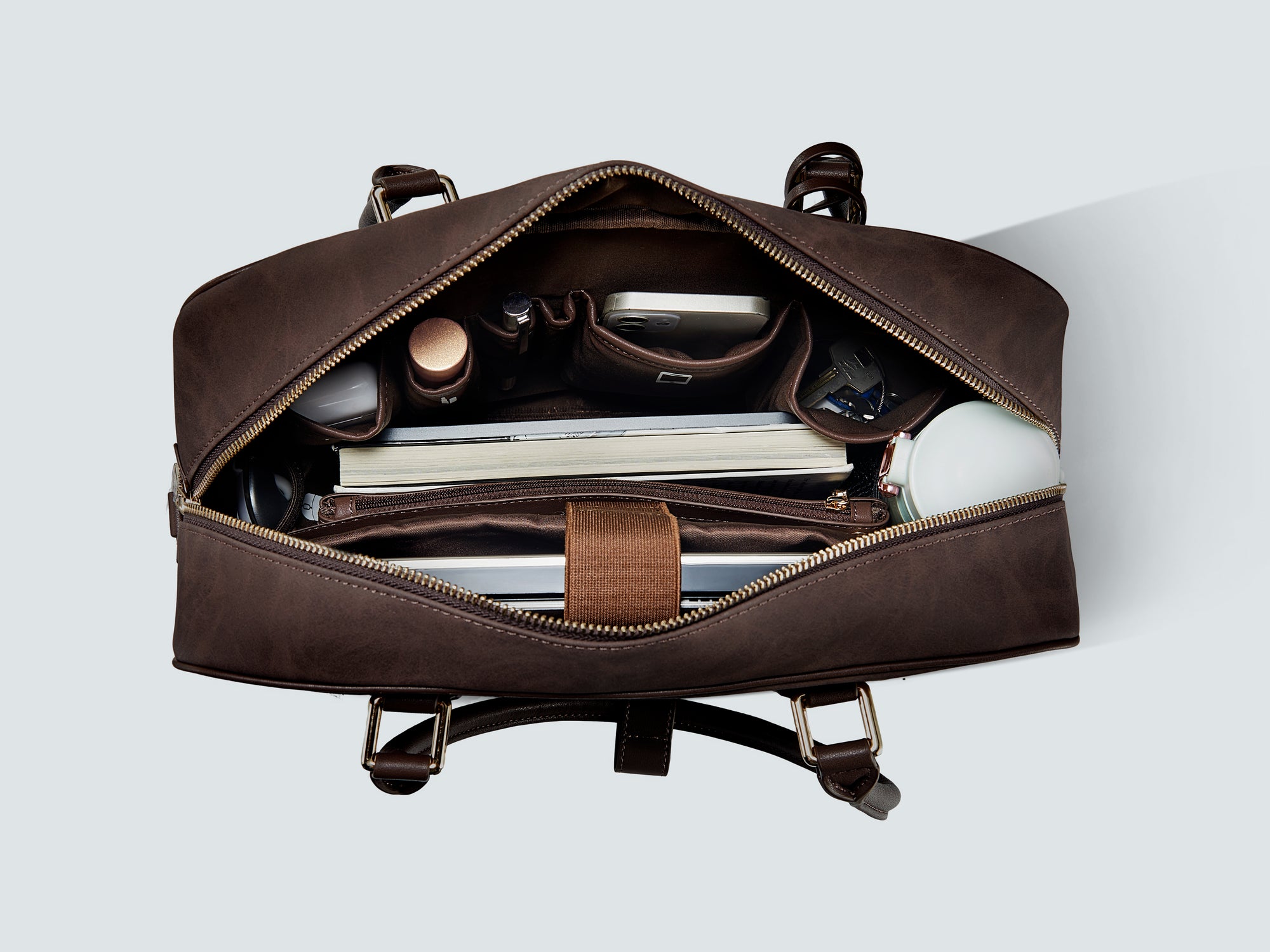 Innenansicht der Victoria Hyde New Work Bag, die perfekte Organisation mit speziellen Fächern für Laptop, Tablet, Handy und Schlüssel im Vergleich zu traditionellen Handtaschen zeigt.